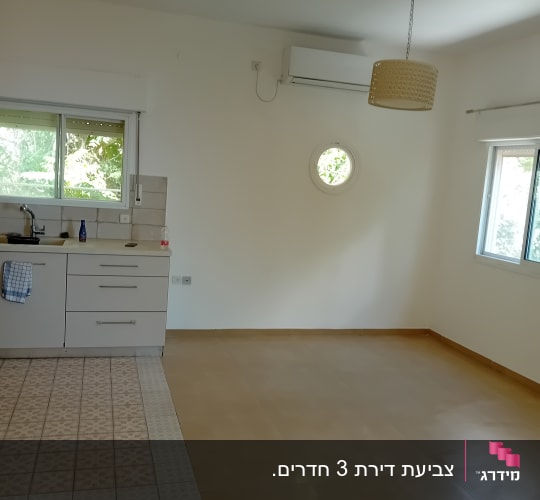 חדר ריק עם מטבח קטן ומזגן על הקיר